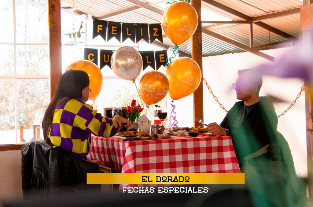 Pareja disfrutando del almuerzo en una mesa de cumpleaños decorada en Parapente El Dorado